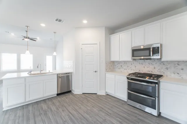 a kitchen with stainless steel appliances kitchen island a sink stove and refrigerator