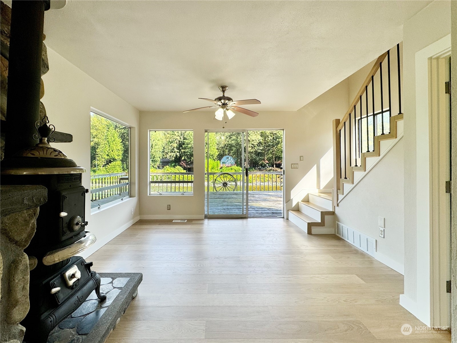 51603 South Riverside Road Gold Bar, WA 98251 - Photo 18 of 38 wooden floor in an empty room with a fireplace and a floor to ceiling window