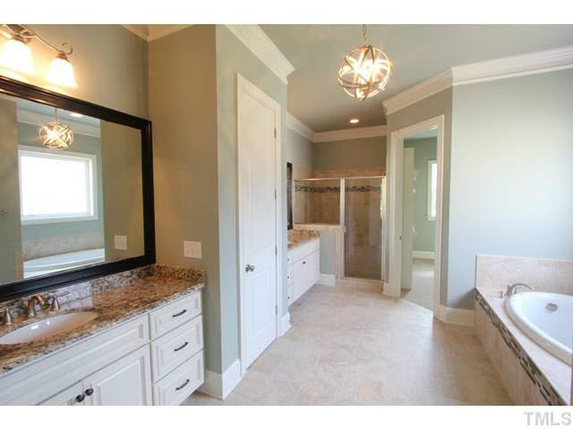 3208 Bryant Falls Court Raleigh, NC 27613 - Photo 10 of 25 a spacious bathroom with a granite countertop sink a mirror and a shower