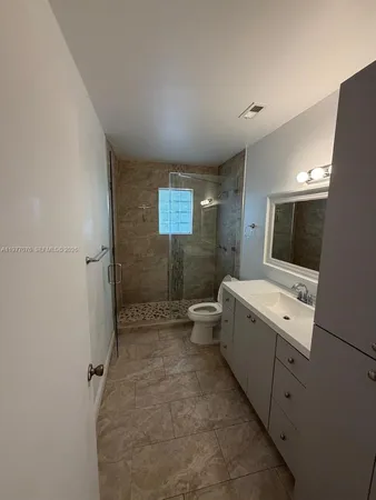 a spacious bathroom with a toilet sink a mirror and a shower