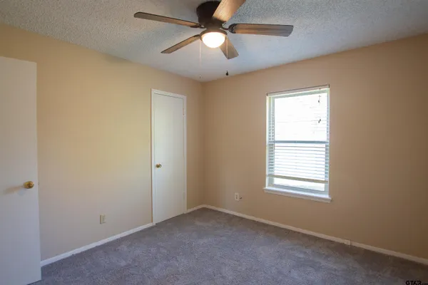 an empty room with a window and a fan