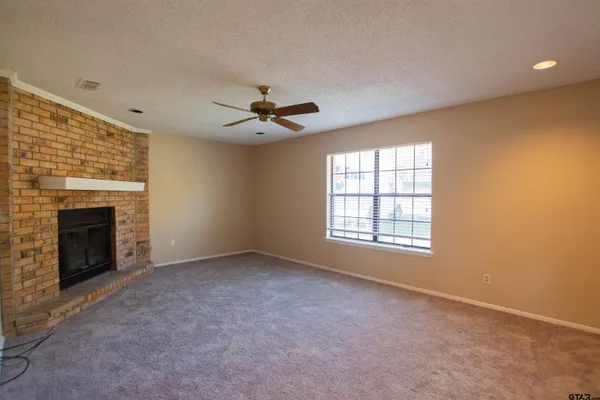 a view of an empty room with a fireplace and a window