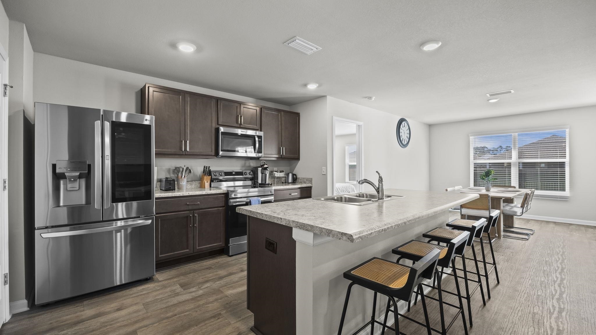 224 Burnston Way Foley, AL 36535 - Photo 11 of 42 Kitchen with stainless steel appliances, dark brown cabinetry, light countertops, dark wood finished floors, and recessed lighting