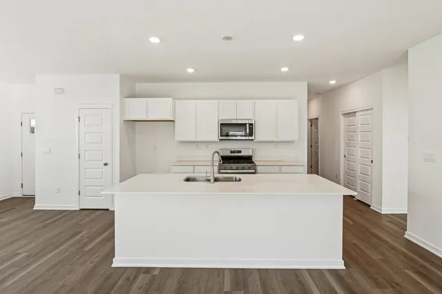 a kitchen with stainless steel appliances a refrigerator sink and microwave