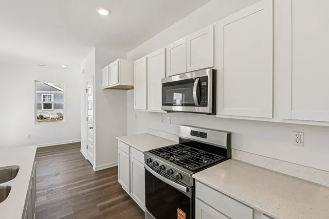 a kitchen with granite countertop a stove and a microwave