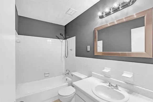 a bathroom with a toilet a sink a bathtub and a mirror