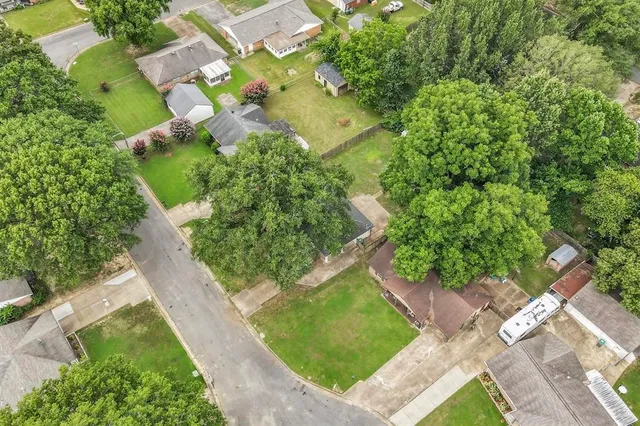 an aerial view of a residential houses with yard
