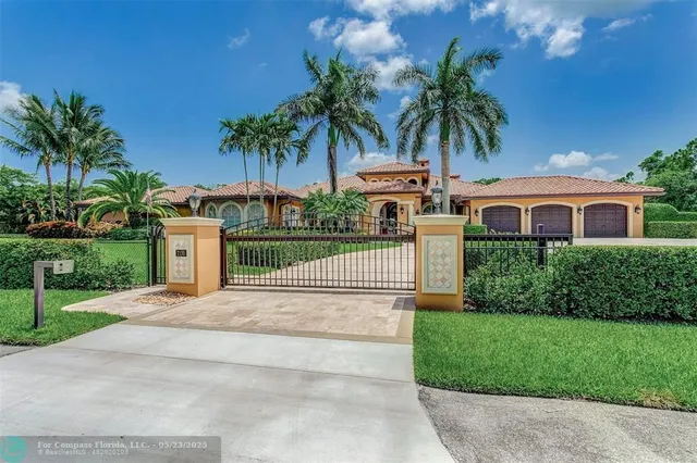 front view of house with a yard and palm trees