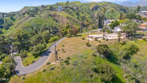an aerial view of residential houses with outdoor space and trees