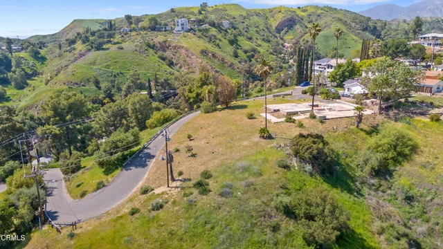 an aerial view of residential houses with outdoor space and trees