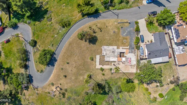 an aerial view of residential house with outdoor space and trees all around