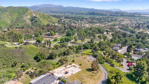an aerial view of residential house with outdoor space and trees all around