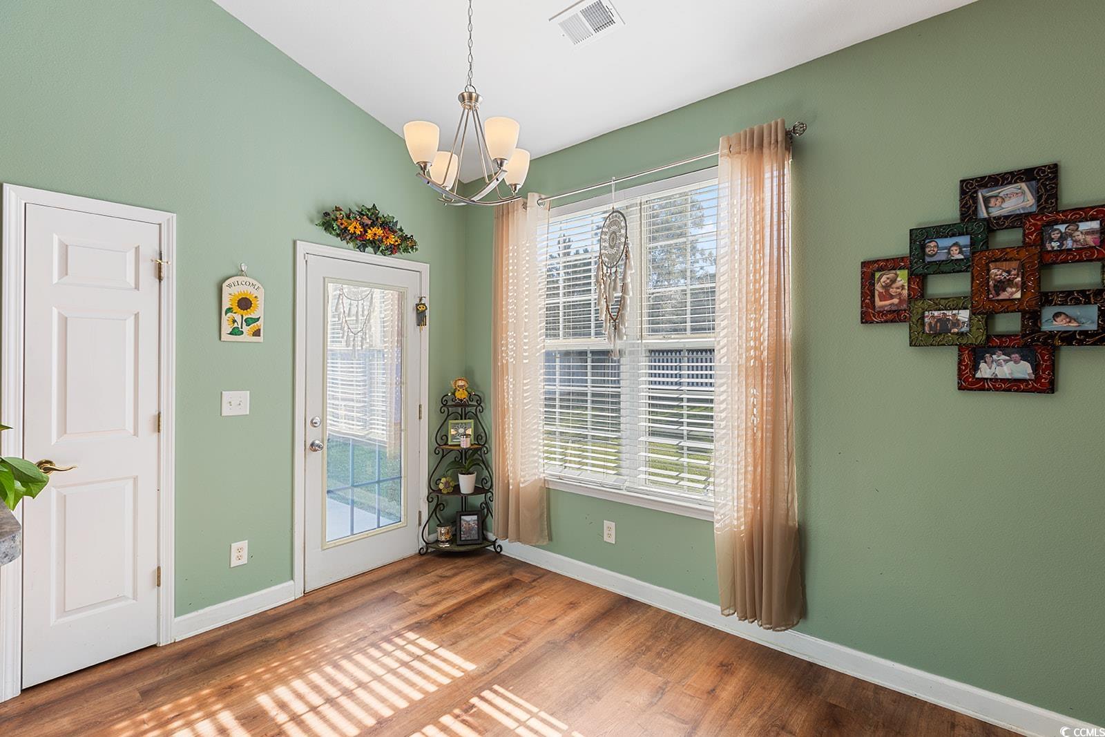 720 Gazania Lane Myrtle Beach, SC 29579 - Photo 12 of 32 Dining room featuring wood finished floors, a chandelier, and lofted ceiling
