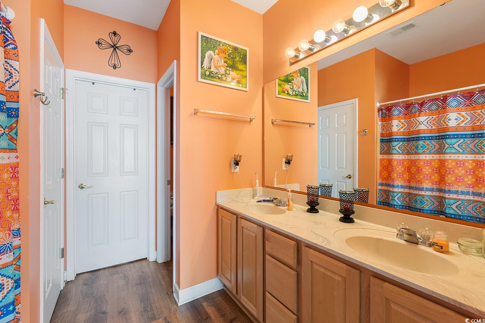 720 Gazania Lane Myrtle Beach, SC 29579 - Photo 16 of 32 Full bathroom with a shower with curtain, double vanity, and dark wood-type flooring