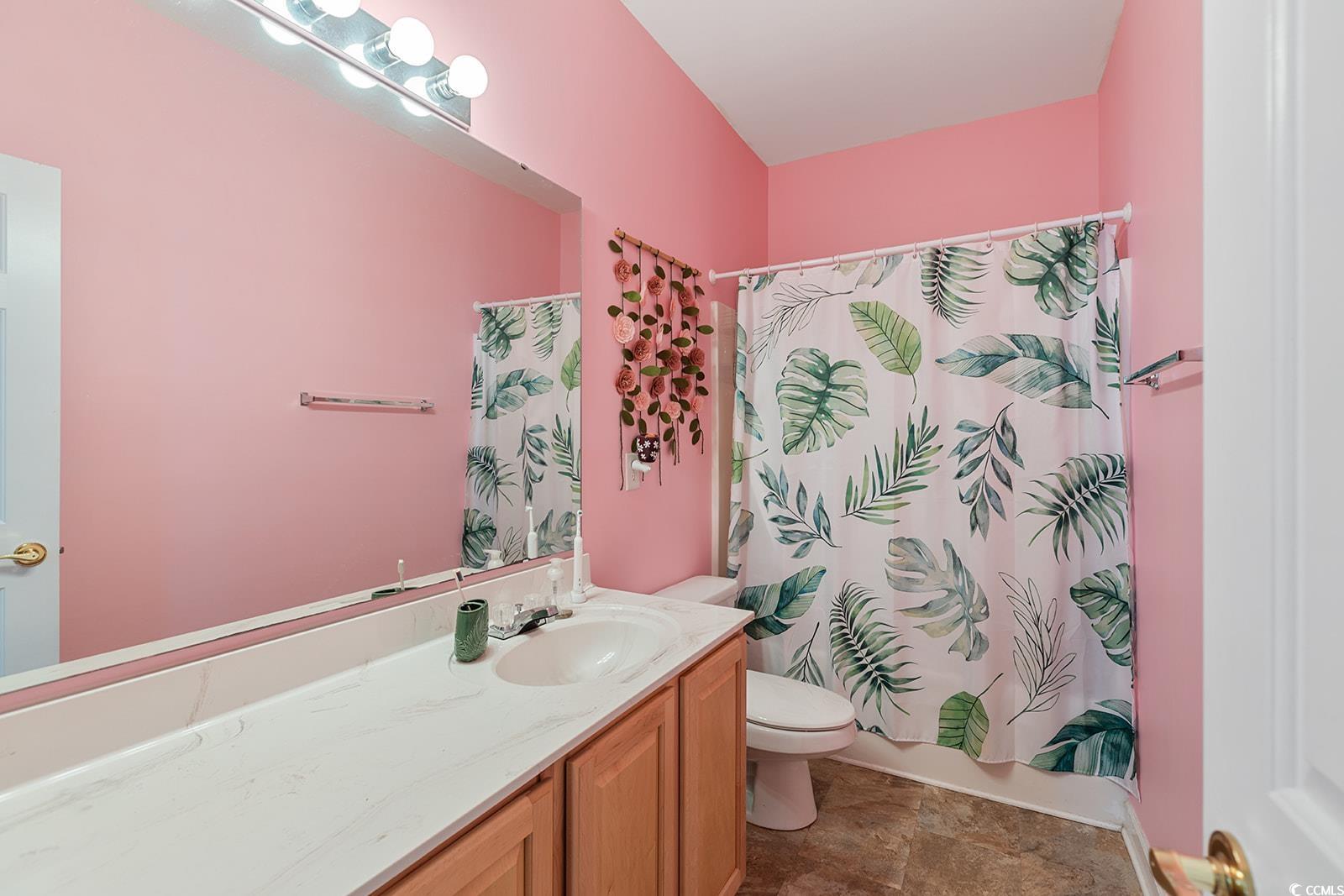 720 Gazania Lane Myrtle Beach, SC 29579 - Photo 23 of 32 Full bathroom with vanity, shower / tub combo with curtain, and stone finish flooring