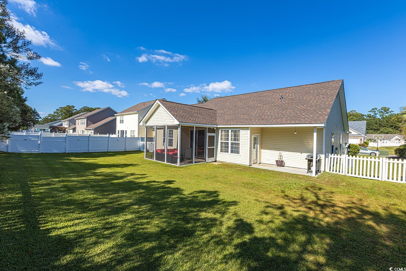 720 Gazania Lane Myrtle Beach, SC 29579 - Photo 27 of 32 Rear view of property featuring a fenced backyard, a sunroom, roof with shingles, and a patio area
