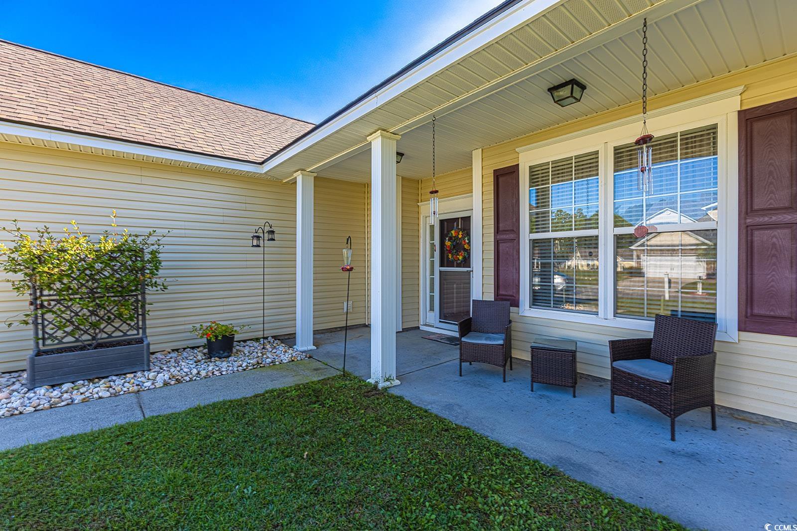 720 Gazania Lane Myrtle Beach, SC 29579 - Photo 3 of 32 Doorway to property featuring roof with shingles, a yard, and a porch