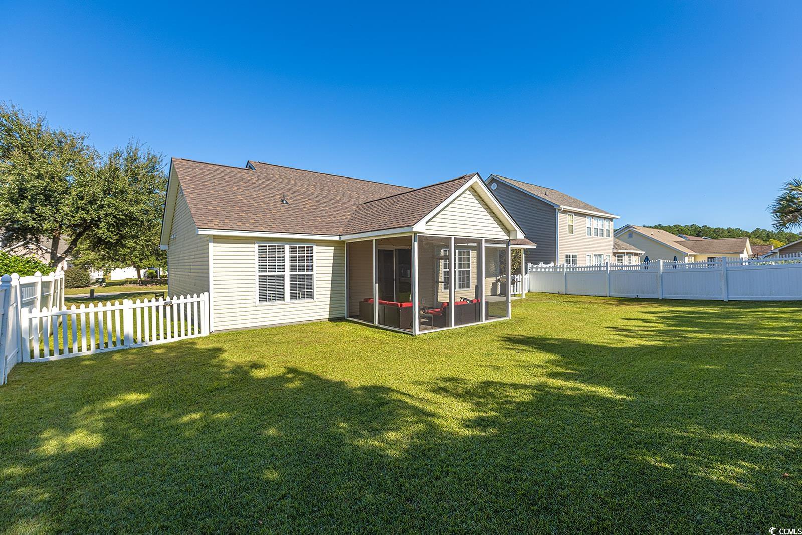 720 Gazania Lane Myrtle Beach, SC 29579 - Photo 4 of 32 Back of property featuring a fenced backyard, a sunroom, and roof with shingles