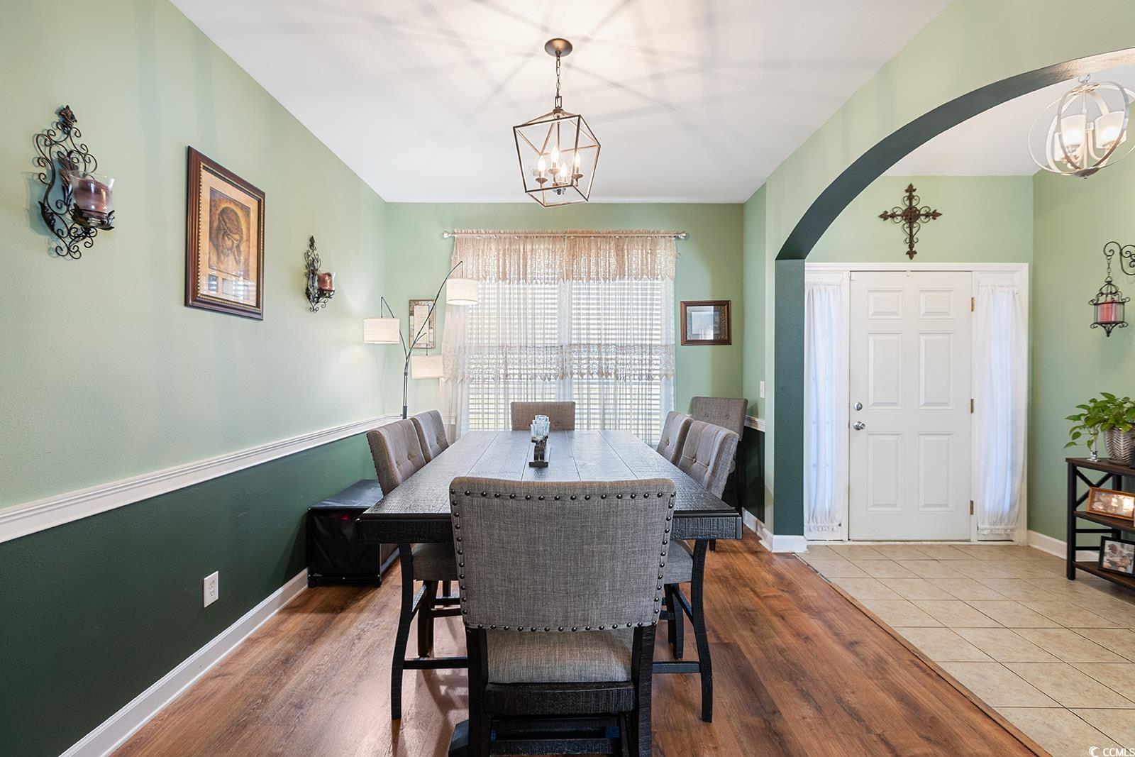 720 Gazania Lane Myrtle Beach, SC 29579 - Photo 10 of 32 Dining space featuring a chandelier, wood finished floors, and arched walkways