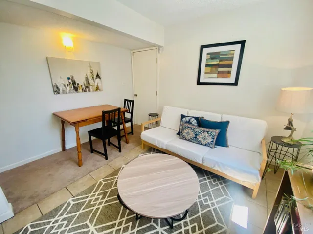 a living room with furniture and a painting on the wall