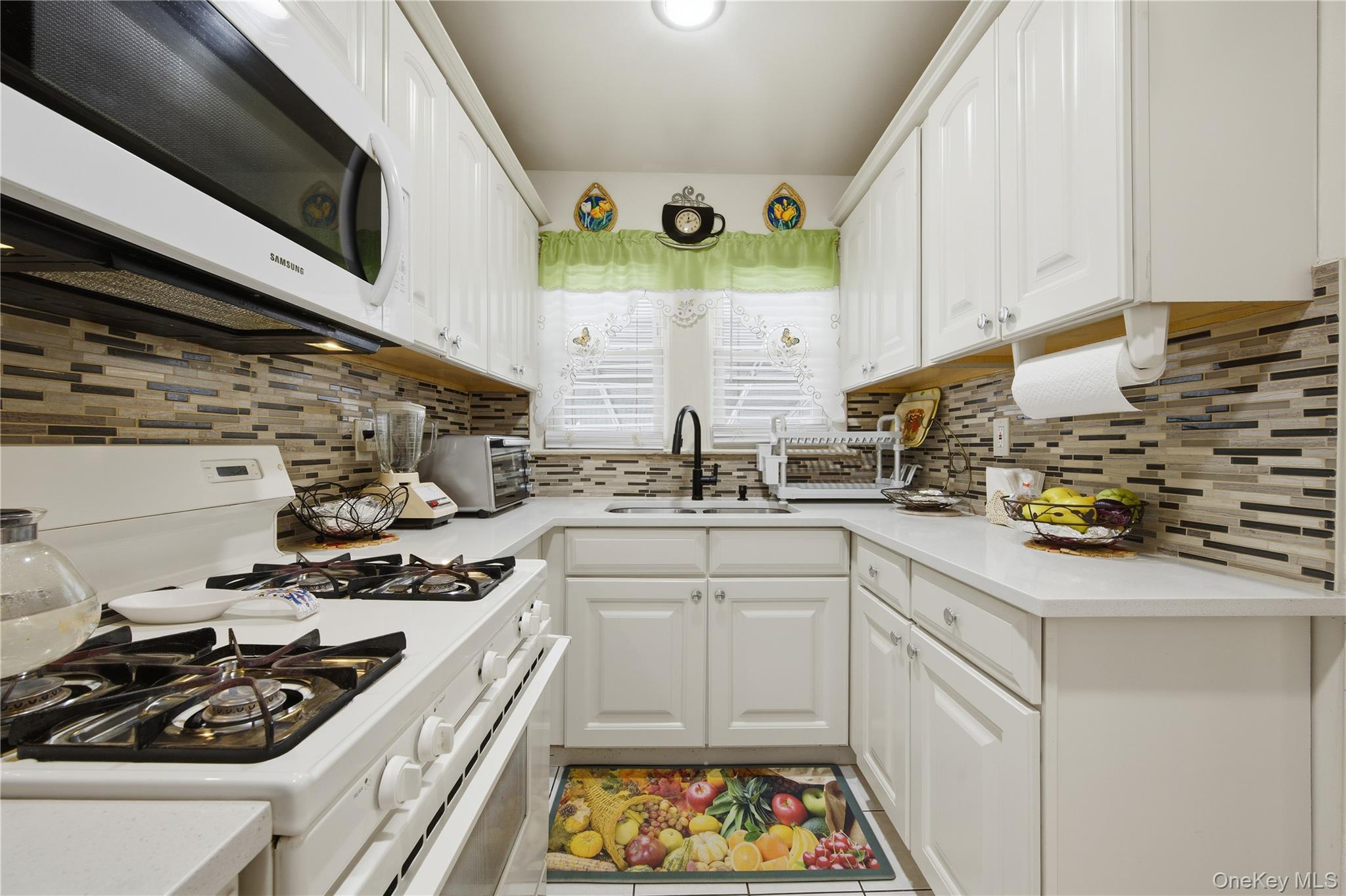 131-58 223rd Street Queens, NY 11413 - Photo 5 of 12 a kitchen with stainless steel appliances a stove a sink and a microwave