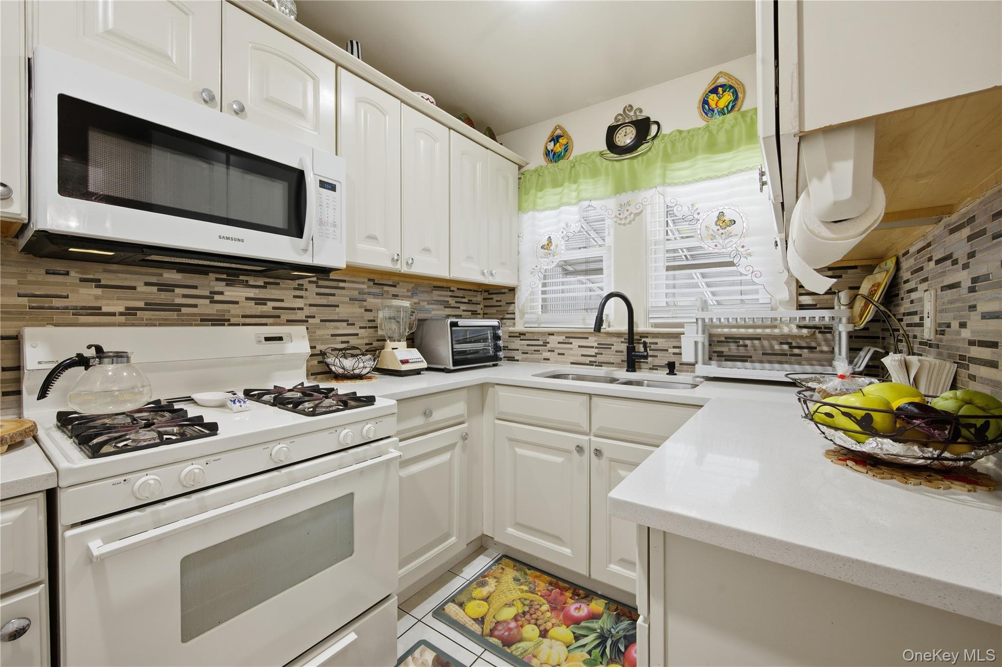 131-58 223rd Street Queens, NY 11413 - Photo 6 of 12 a kitchen with stainless steel appliances a stove a sink and a microwave