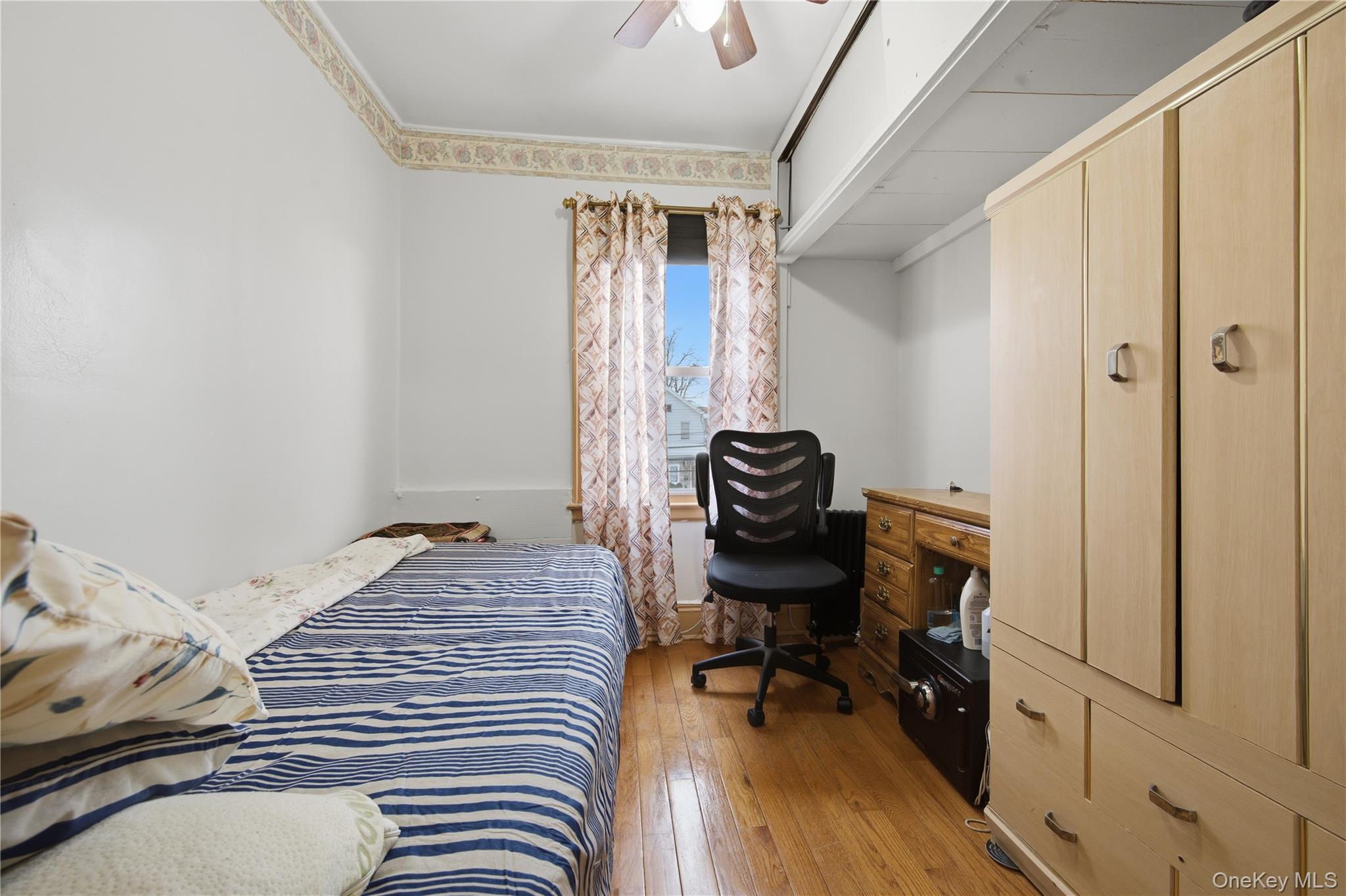 131-58 223rd Street Queens, NY 11413 - Photo 8 of 12 a bedroom with a bed and a window