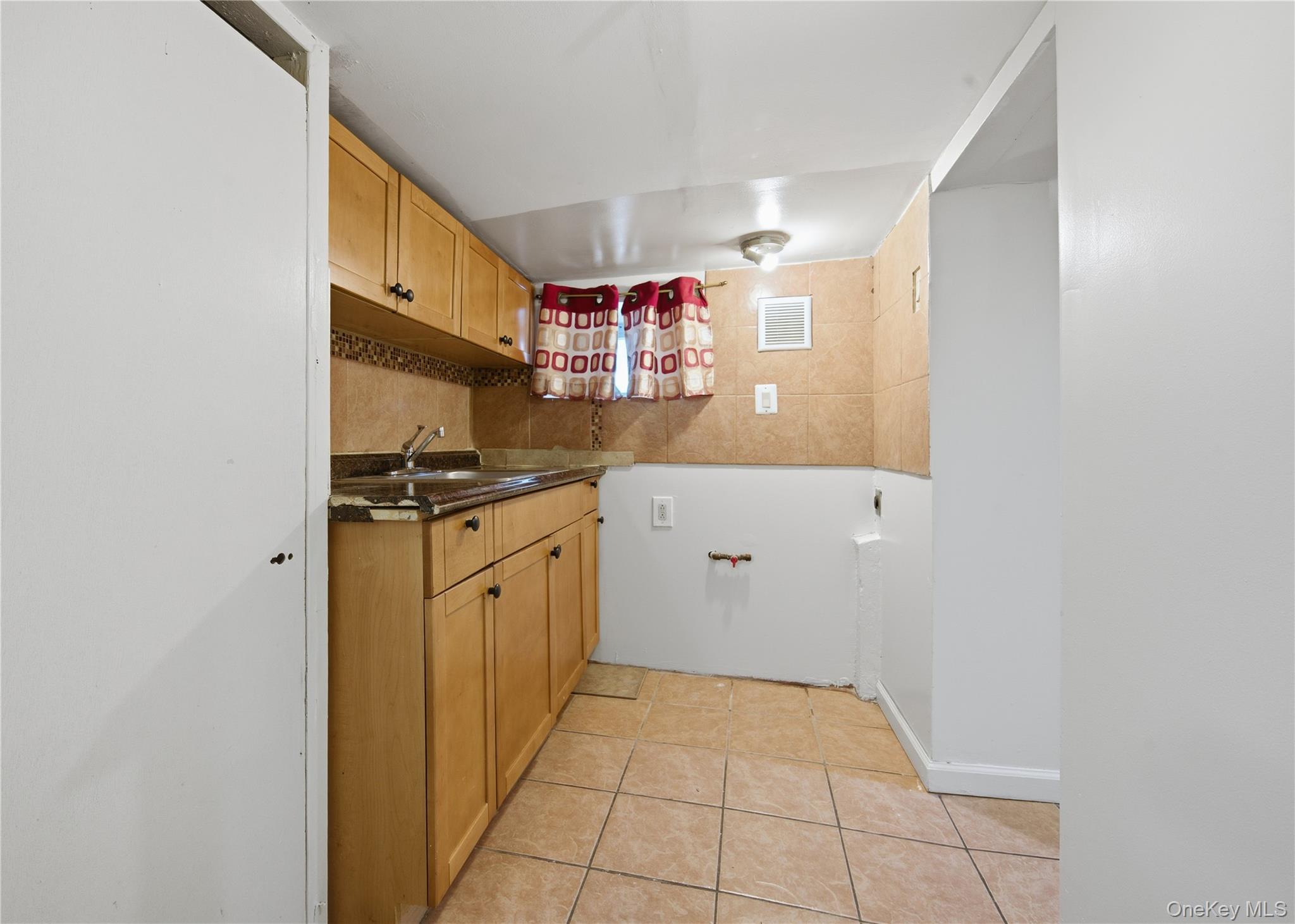 131-58 223rd Street Queens, NY 11413 - Photo 9 of 12 a kitchen with cabinets and window