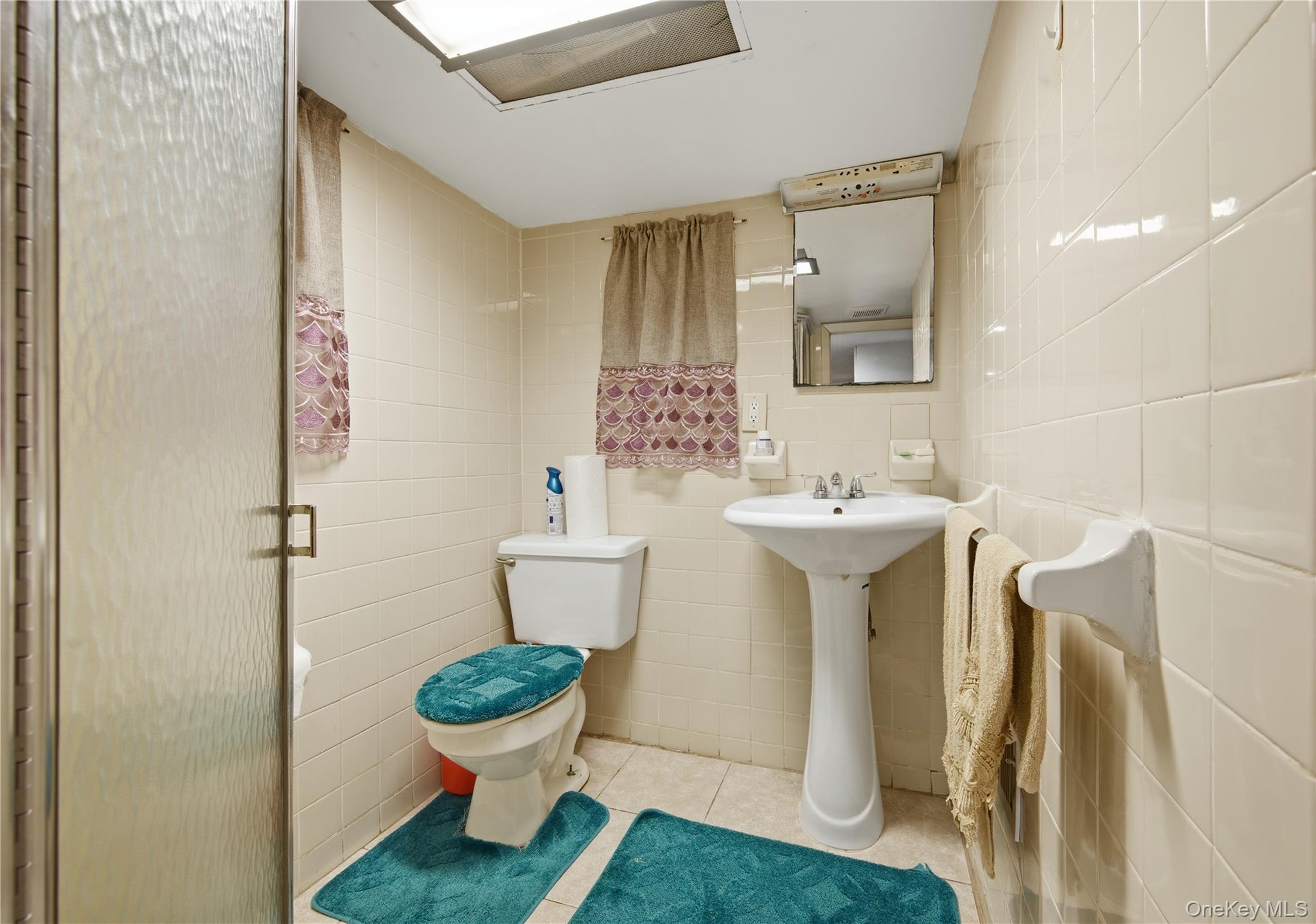 131-58 223rd Street Queens, NY 11413 - Photo 10 of 12 a bathroom with a sink mirror toilet and a shower