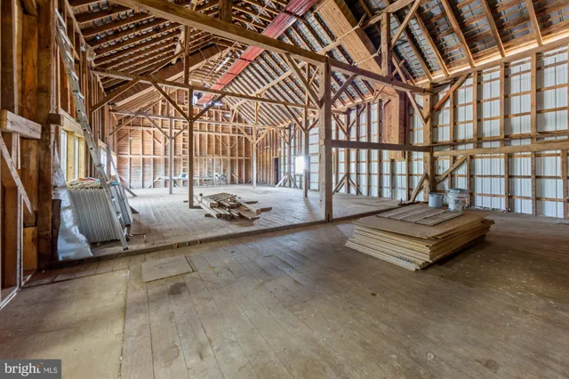 a view of a hallway to a livingroom with furniture and a window