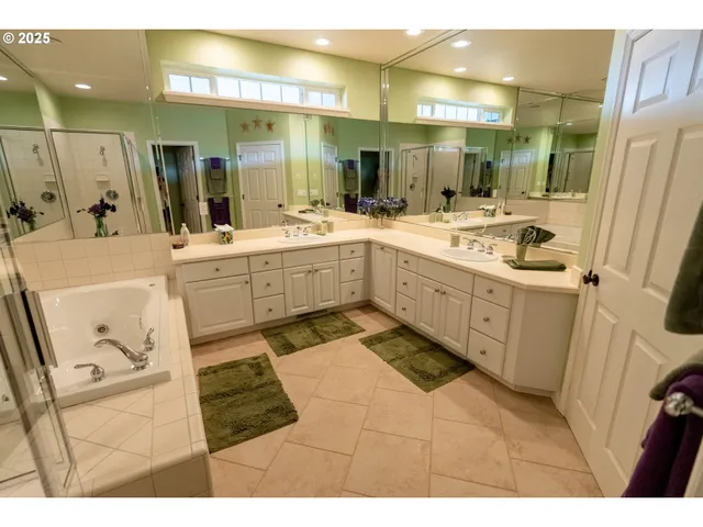 a large bathroom with a sink mirror and a bath tub