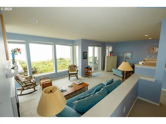 a living room with furniture and large windows