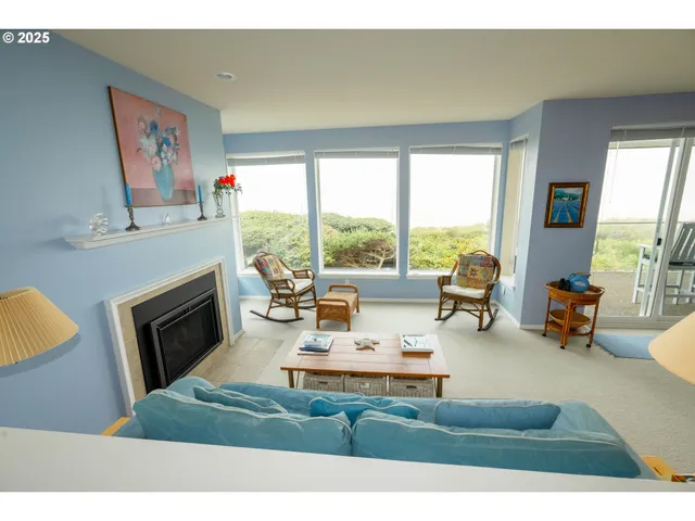 a living room with fireplace furniture and a large window