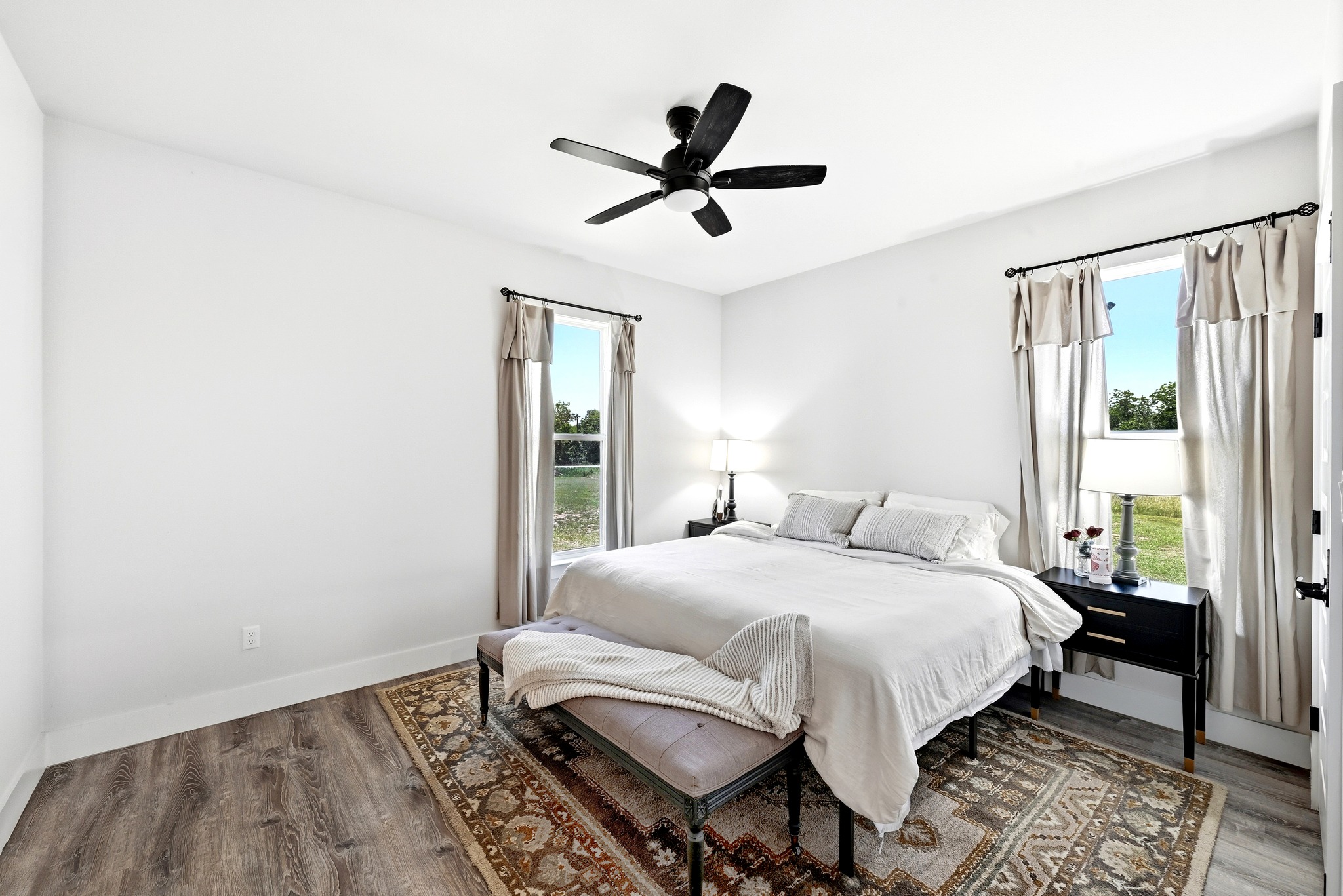 2889 Old McMahan Road Lockhart, TX 78644 - Photo 22 of 33 Hardwood floors and bright windows illuminate this comfortable bedroom space.