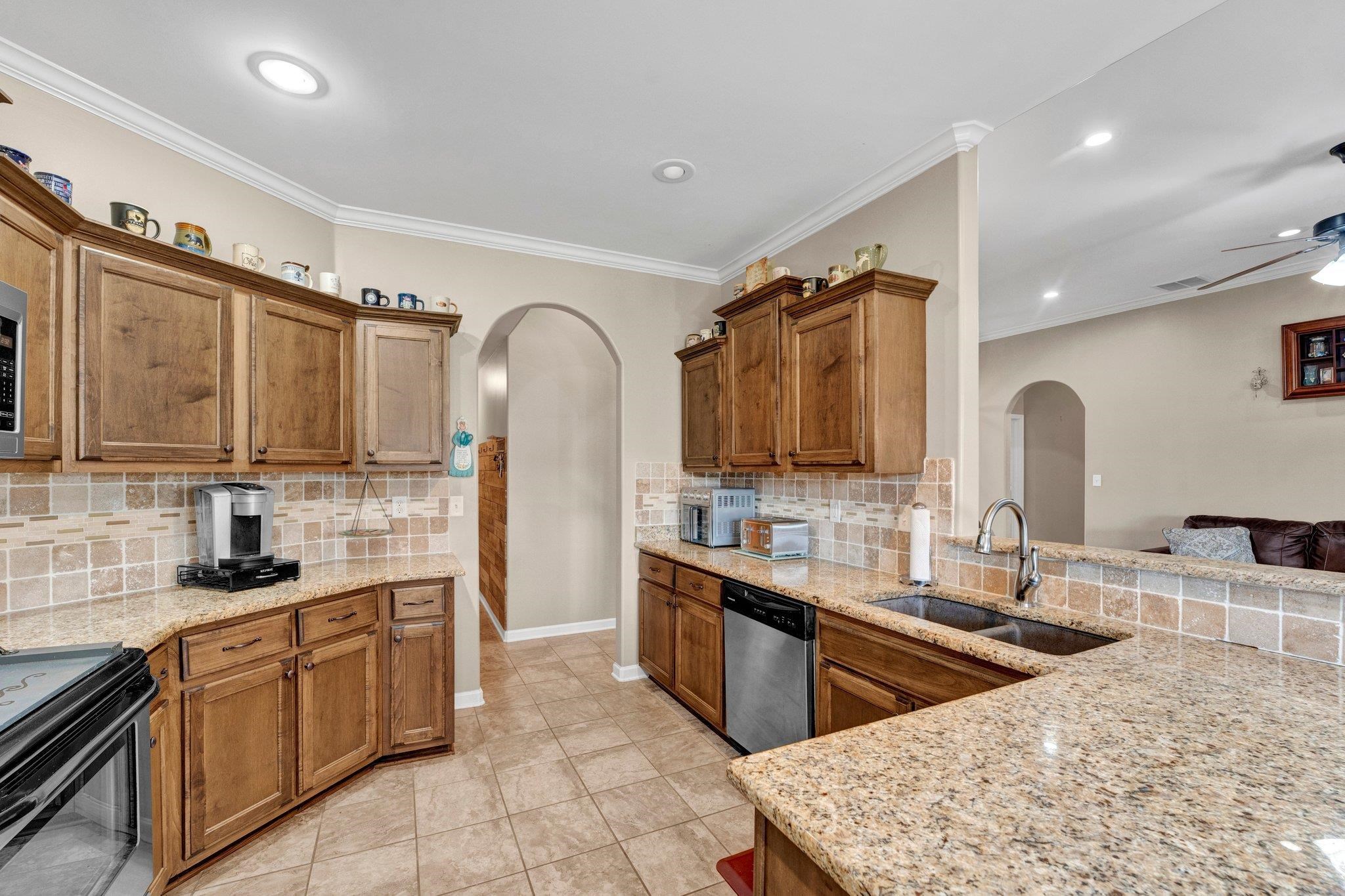 250 Pearl Road Somerville, TN 38068 - Photo 7 of 13 Kitchen featuring ceiling fan, dishwasher, sink, crown molding, and decorative backsplash