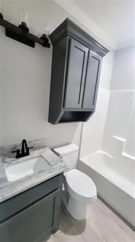 a bathroom with a granite countertop toilet sink and mirror