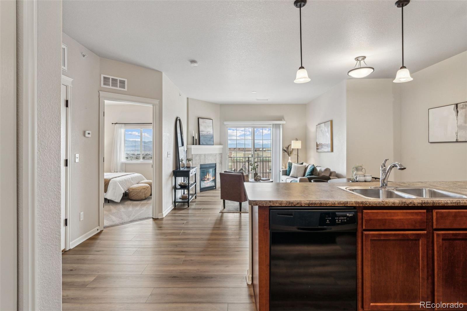 1062 Rockhurst Drive, Unit 401 Highlands Ranch, CO 80129 - Photo 22 of 41 a view of a dining room and livingroom with furniture wooden floor a chandelier