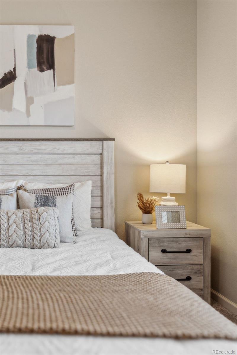1062 Rockhurst Drive, Unit 401 Highlands Ranch, CO 80129 - Photo 24 of 41 a bedroom with a bed and a night stand