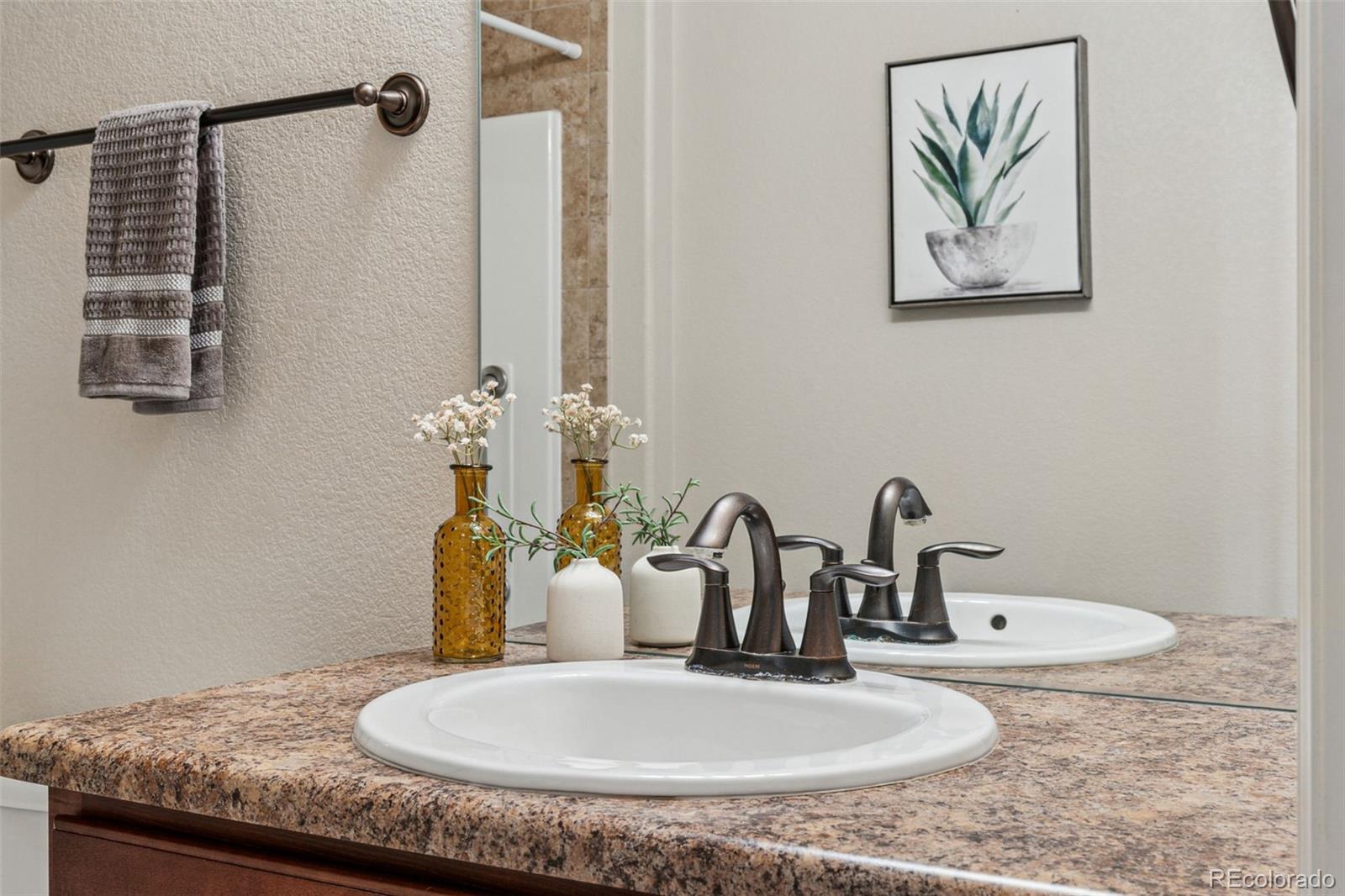 1062 Rockhurst Drive, Unit 401 Highlands Ranch, CO 80129 - Photo 32 of 41 a bathroom with a granite countertop sink and a mirror