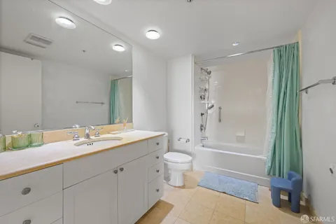 a en suite bathroom with a granite countertop sink and a mirror