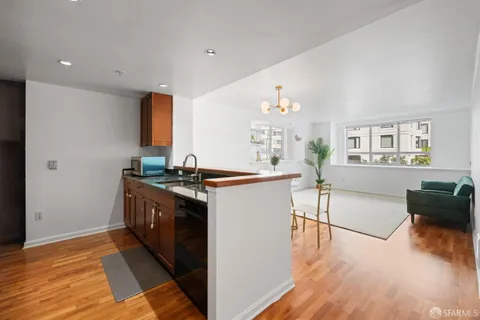 a kitchen with stainless steel appliances granite countertop a stove and a wooden floors