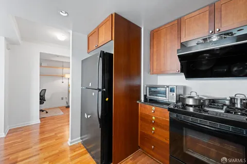a kitchen with stainless steel appliances granite countertop a refrigerator and a stove top oven
