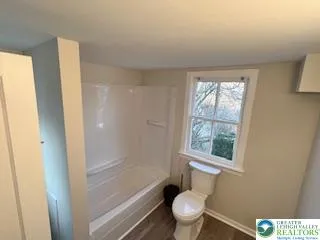 a bathroom with a toilet window and shower