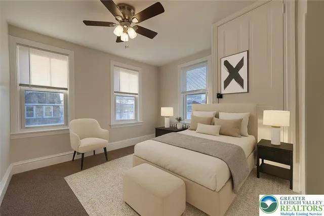 a bedroom with a bed and chair next to a window