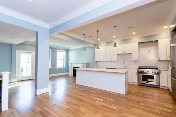 a large kitchen with a wooden floor and a stove top oven