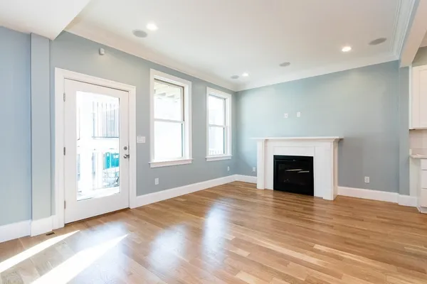 an empty room with windows and fireplace