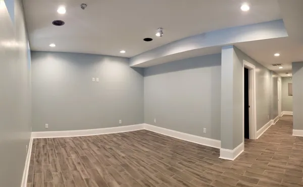 a view of empty room with wooden floor