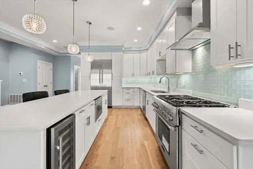 a large kitchen with a stove and a view of wooden floor