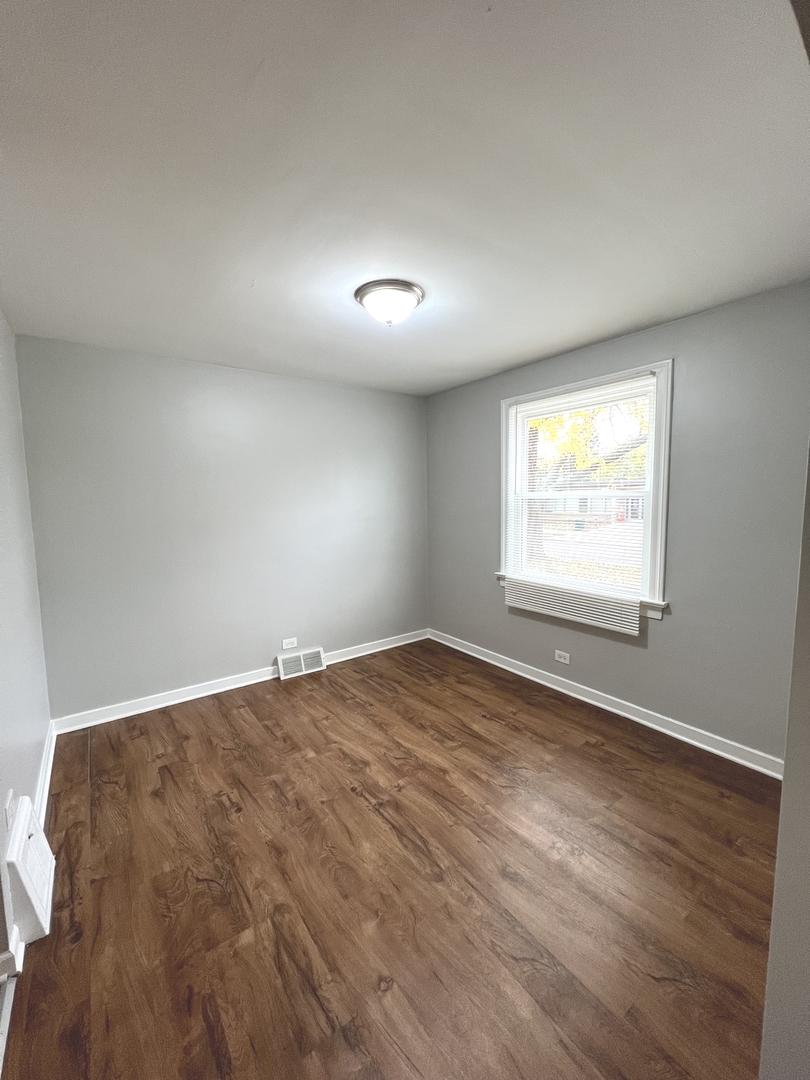 4409 Home Avenue Stickney, IL 60402 - Photo 11 of 21 an empty room with wooden floor and windows