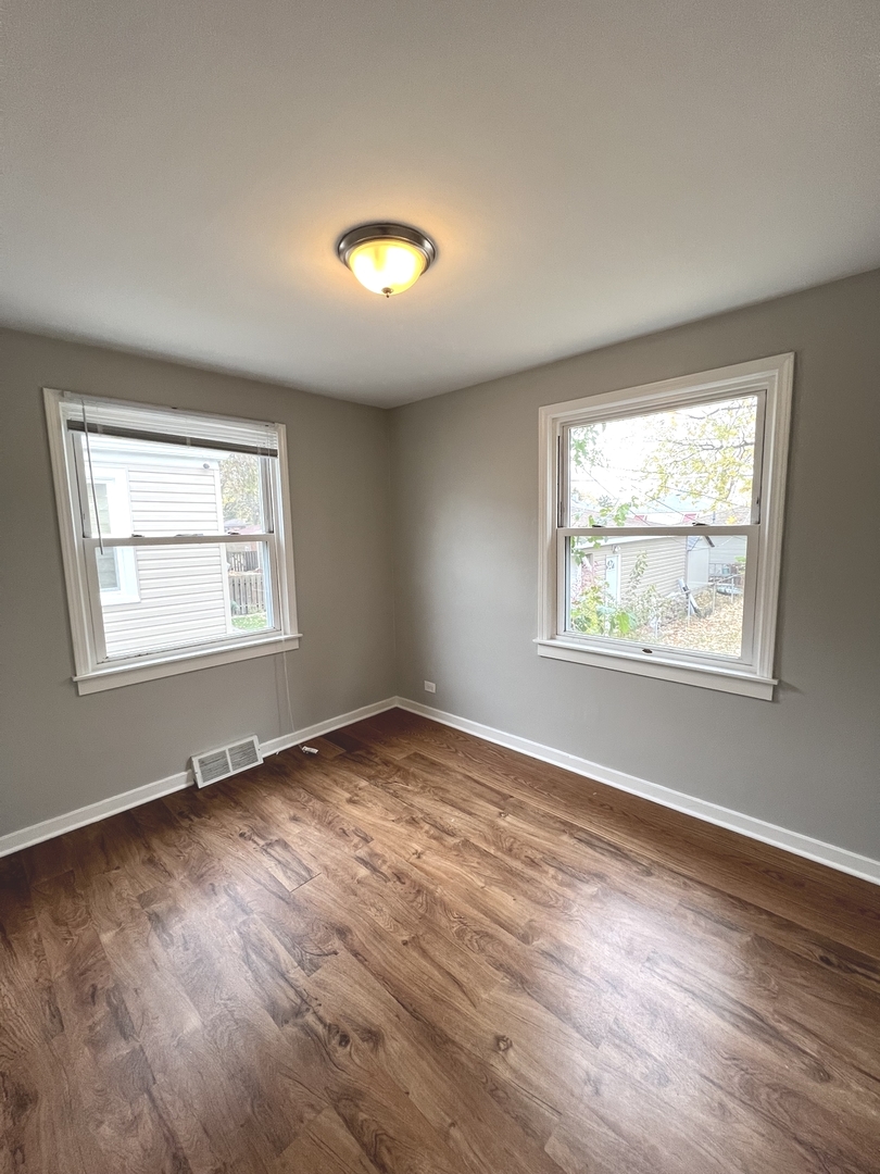 4409 Home Avenue Stickney, IL 60402 - Photo 14 of 21 an empty room with wooden floor and windows